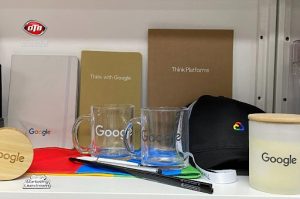 Branded promotional products for exhibitions and trade shows in Australia, including mugs, notebooks, caps, and pens display.