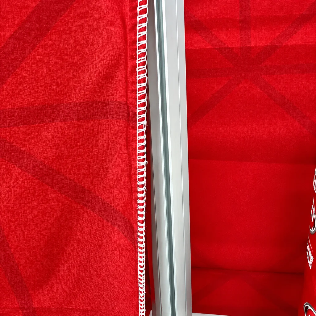 Close-up of a FABriX fabric print's stitched silicone edge beside the aluminium frame groove