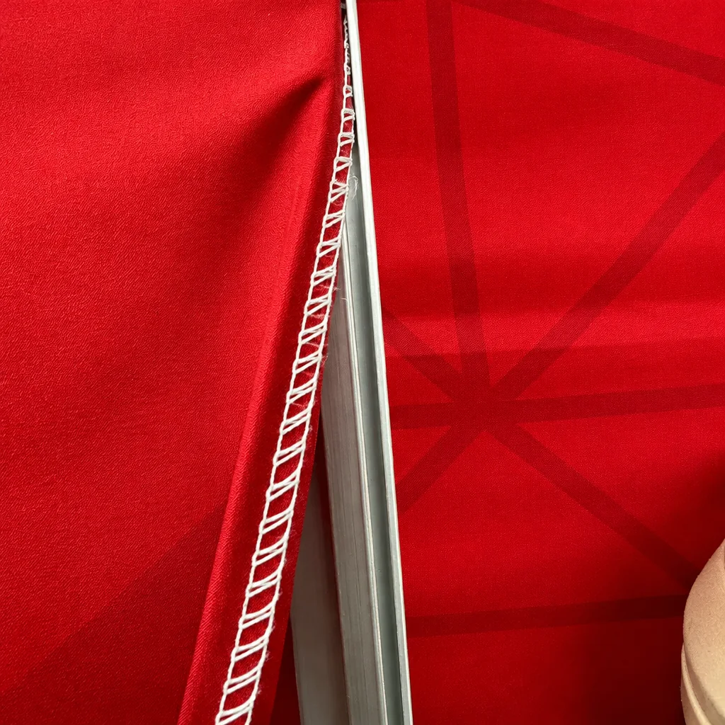 The silicone edge of a FABriX print being pressed into the frame channel by hand